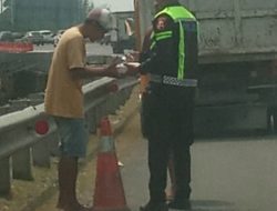 Personil Induk PJR BSD Polantas Karib Bripka Taufan Membagikan Nasi Kotak Kepada Sopir Yang Kendaraannya Rusak di Jalan Tol BSD